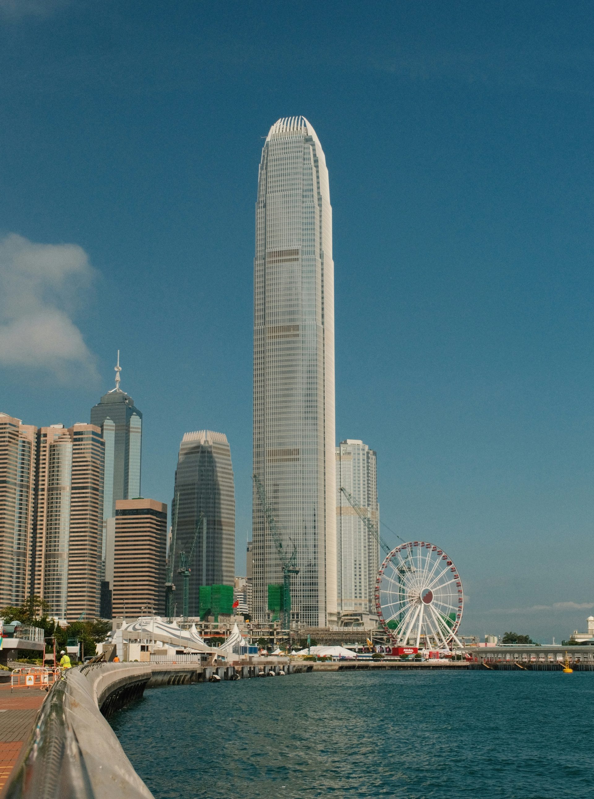 Hong kong skyline with a ferris wheel and skyscrapers.
